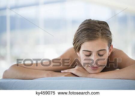 Woman lying on a massage table View Large Photo Image Stock Photography - Woman lying on a massage table. Fotosearch