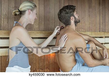 Woman massaging on her friend's back with a massager in a sauna View Large Photo Image Stock Image - Woman massaging on her friend's back with a massager in a sauna. Fotosearch
