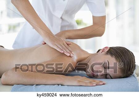 Picture - Woman receiving back massage from a massage therapist. Fotosearch