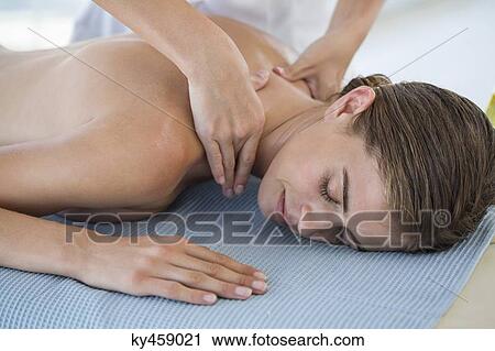 Stock Image - Woman receiving back massage from a massage therapist. Fotosearch