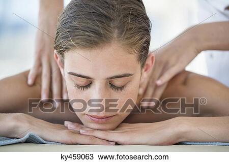 Stock Image - Woman receiving back massage from a massage therapist. Fotosearch