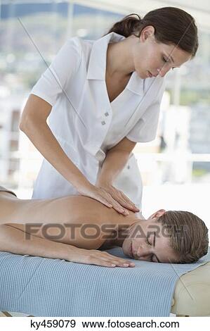 Stock Photo - Woman receiving back massage from a massage therapist. Fotosearch