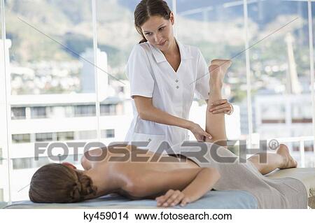 Woman receiving leg massage from a massage therapist View Large Photo Image Picture - Woman receiving leg massage from a massage therapist. Fotosearch
