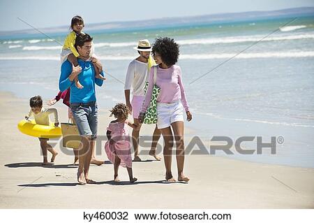 Stock Image - Families walking on the beach. Fotosearch