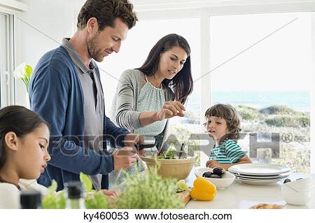 Stock Image - Family preparing food in the kitchen. Fotosearch