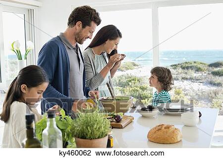 Family preparing food in the kitchen View Large Photo Image Stock Image - Family preparing food in the kitchen. Fotosearch