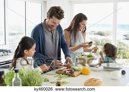 Stock Photograph - Family preparing food in the kitchen. Fotosearch