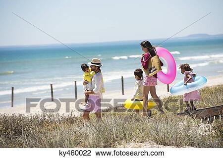 Family walking on a boardwalk on the beach View Large Photo Image Stock Image - Family walking on a boardwalk on the beach. Fotosearch