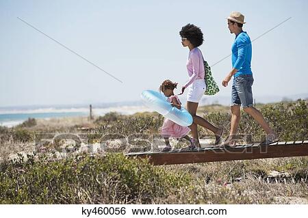 Family walking on a boardwalk on the beach View Large Photo Image Stock Photograph - Family walking on a boardwalk on the beach. Fotosearch