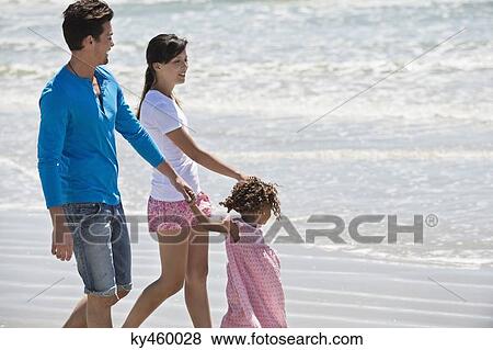 Family walking on the beach View Large Photo Image Stock Photo - Family walking on the beach. Fotosearch