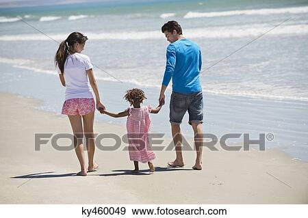 Family walking on the beach View Large Photo Image Stock Photo - Family walking on the beach. Fotosearch