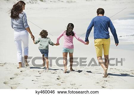 Stock Photograph - Family walking on the beach. Fotosearch