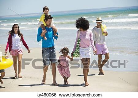Stock Photograph - Family walking on the beach. Fotosearch