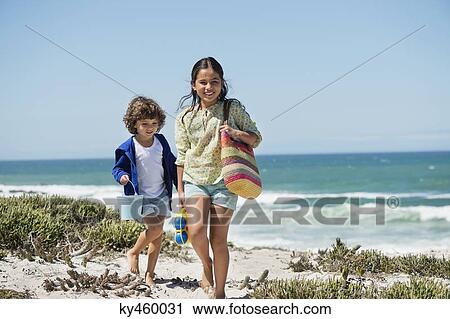 Girl and a boy walking on the beach View Large Photo Image Stock Image - Girl and a boy walking on the beach. Fotosearch