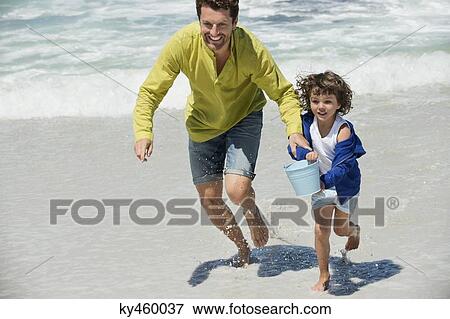 Man playing with his son on the beach View Large Photo Image Stock Photo - Man playing with his son on the beach. Fotosearch