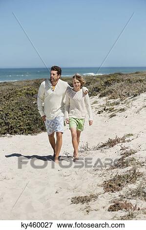 Man walking with his son on the beach View Large Photo Image Stock Photo - Man walking with his son on the beach. Fotosearch