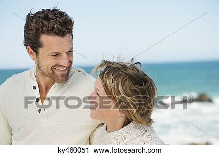 Man with his son smiling on the beach View Large Photo Image Stock Image - Man with his son smiling on the beach. Fotosearch