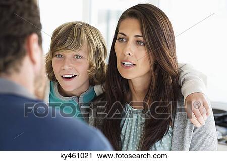 Stock Image - Boy with his parents discussing at home. Fotosearch