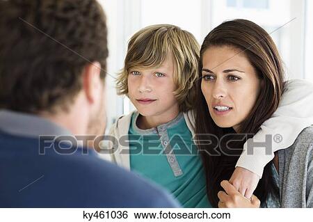 Stock Photograph - Boy with his parents discussing at home. Fotosearch