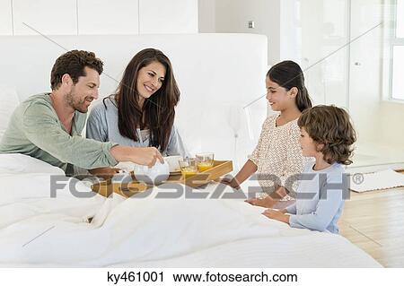 Children serving tea to their parents on the bed View Large Photo Image Stock Image - Children serving tea to their parents on the bed. Fotosearch