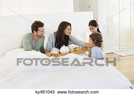 Children serving tea to their parents on the bed View Large Photo Image Stock Photography - Children serving tea to their parents on the bed. Fotosearch