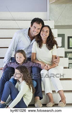 Stock Photograph - Couple with their children sitting on steps. Fotosearch