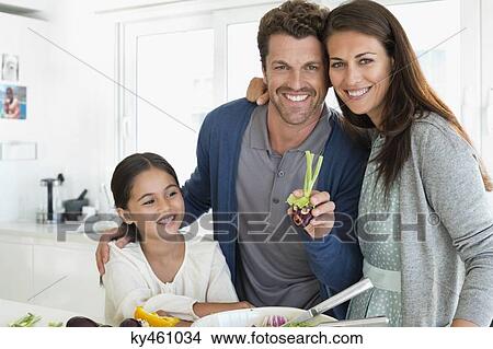 Couple with their daughter enjoying in the kitchen View Large Photo Image Picture - Couple with their daughter enjoying in the kitchen. Fotosearch