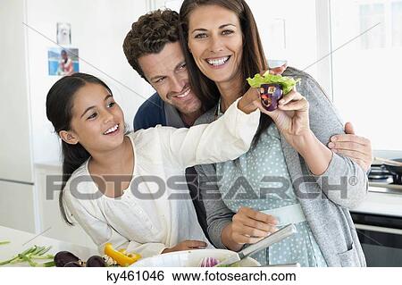 Couple with their daughter enjoying in the kitchen View Large Photo Image Stock Photograph - Couple with their daughter enjoying in the kitchen. Fotosearch