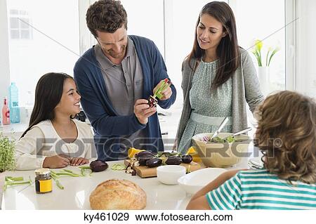 Family preparing food in the kitchen View Large Photo Image Stock Photo - Family preparing food in the kitchen. Fotosearch