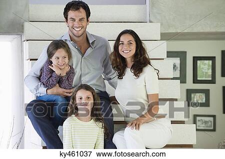 Stock Photo - Family sitting on steps and smiling. Fotosearch