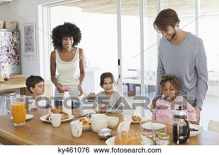 Family smiling at a breakfast table View Large Photo Image Stock Photograph - Family smiling at a breakfast table. Fotosearch