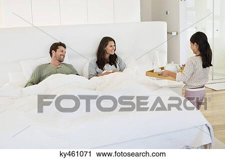 Girl serving tea to her parents on the bed View Large Photo Image Stock Image - Girl serving tea to her parents on the bed. Fotosearch