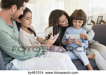 Picture - Parents showing photographs to their children. Fotosearch