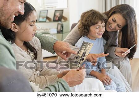 Parents showing photographs to their children View Large Photo Image Stock Image - Parents showing photographs to their children. Fotosearch