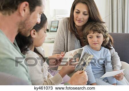 Parents showing photographs to their children View Large Photo Image Stock Image - Parents showing photographs to their children. Fotosearch