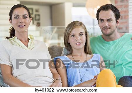 Portrait of a family sitting on a couch and smiling View Large Photo Image Stock Image - Portrait of a family sitting on a couch and smiling. Fotosearch