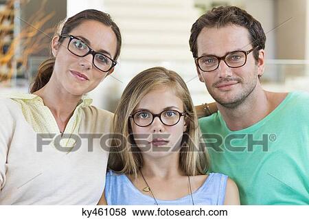 Portrait of a family sitting on a couch and wearing eyeglasses View Large Photo Image Stock Photo - Portrait of a family sitting on a couch and wearing eyeglasses. Fotosearch