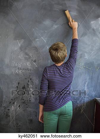 Boy cleaning blackboard with a duster in a classroom View Large Photo Image Stock Image - Boy cleaning blackboard with a duster in a classroom. Fotosearch