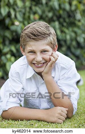 Picture - Boy lying on grass. Fotosearch