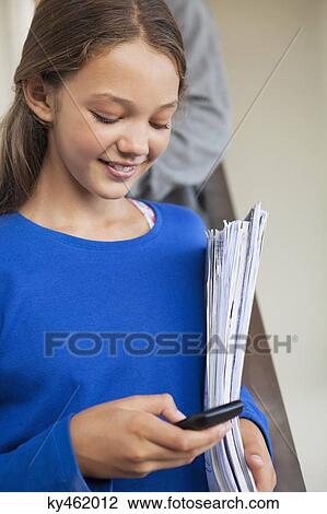 Stock Image - Close-up of a girl text messaging on a mobile phone. Fotosearch