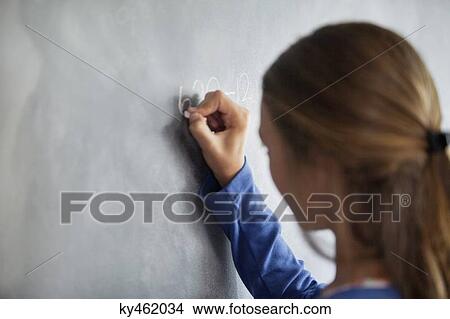 Close-up of a girl writing on a blackboard in a classroom View Large Photo Image Picture - Close-up of a girl writing on a blackboard in a classroom. Fotosearch