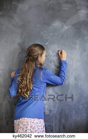 Close-up of a girl writing on a blackboard in a classroom View Large Photo Image Stock Image - Close-up of a girl writing on a blackboard in a classroom. Fotosearch