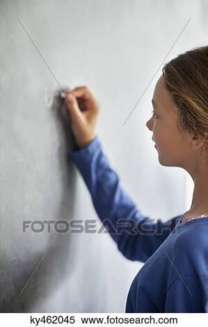 Close-up of a girl writing on a blackboard in a classroom View Large Photo Image Stock Photography - Close-up of a girl writing on a blackboard in a classroom. Fotosearch
