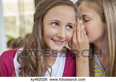 Close-up of two girls whispering in a school View Large Photo Image Stock Photograph - Close-up of two girls whispering in a school. Fotosearch