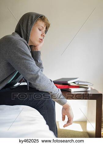 Teenage boy sitting on the bed and thinking View Large Photo Image Stock Photography - Teenage boy sitting on the bed and thinking. Fotosearch