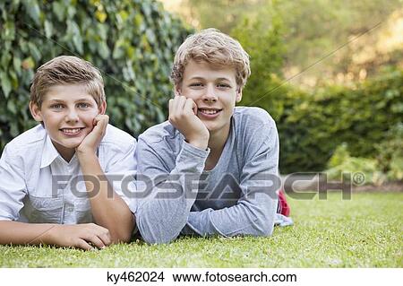 Two friends lying on grass View Large Photo Image Picture - Two friends lying on grass. Fotosearch