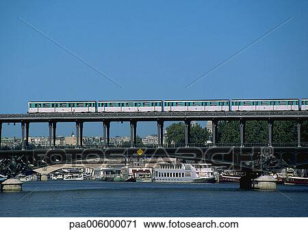 Stock Image - France, Paris, subway train on bridge over river.. Fotosearch