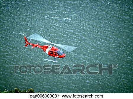 Helicopter flying over water. View Large Photo Image Stock Photo - Helicopter flying over water.. Fotosearch