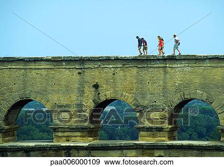 Stock Photo - People walking over aqueduct.. Fotosearch