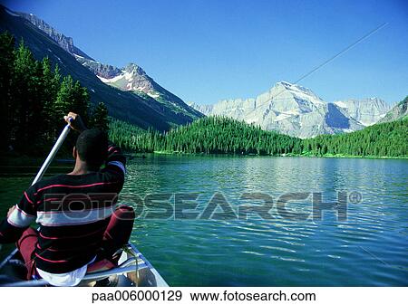 USA, man paddling boat in mountainous region. View Large Photo Image Stock Photo - USA, man paddling boat in mountainous region.. Fotosearch